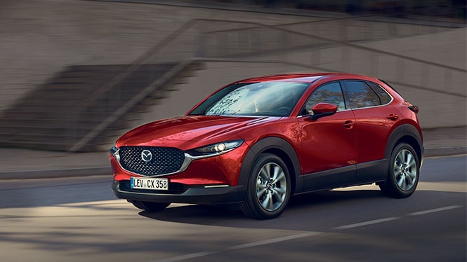 Mazda CX-30 Gebrauchtwagen in rot von schräg vorne während der Fahrt