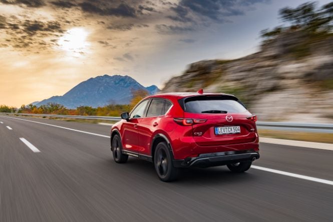 Der neue Mzda CX-5 in Magmarot Metallic von hinten bei der Fahrt