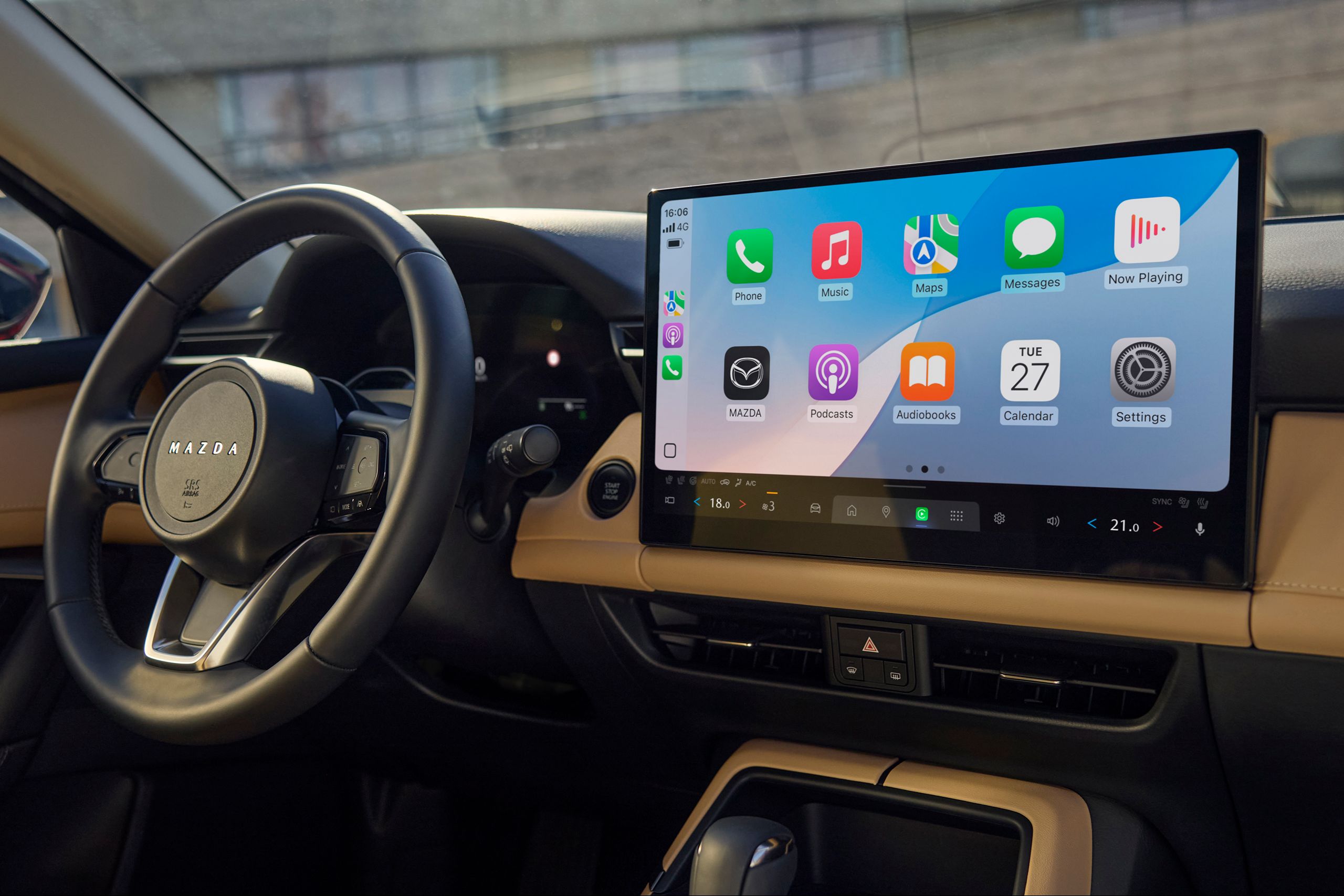 Nahaufnahme des Cockpits im Mazda CX-5 2025 mit großem Touchdisplay und Apple CarPlay-Benutzeroberfläche – modernes Design in schwarzer und beiger Optik.
