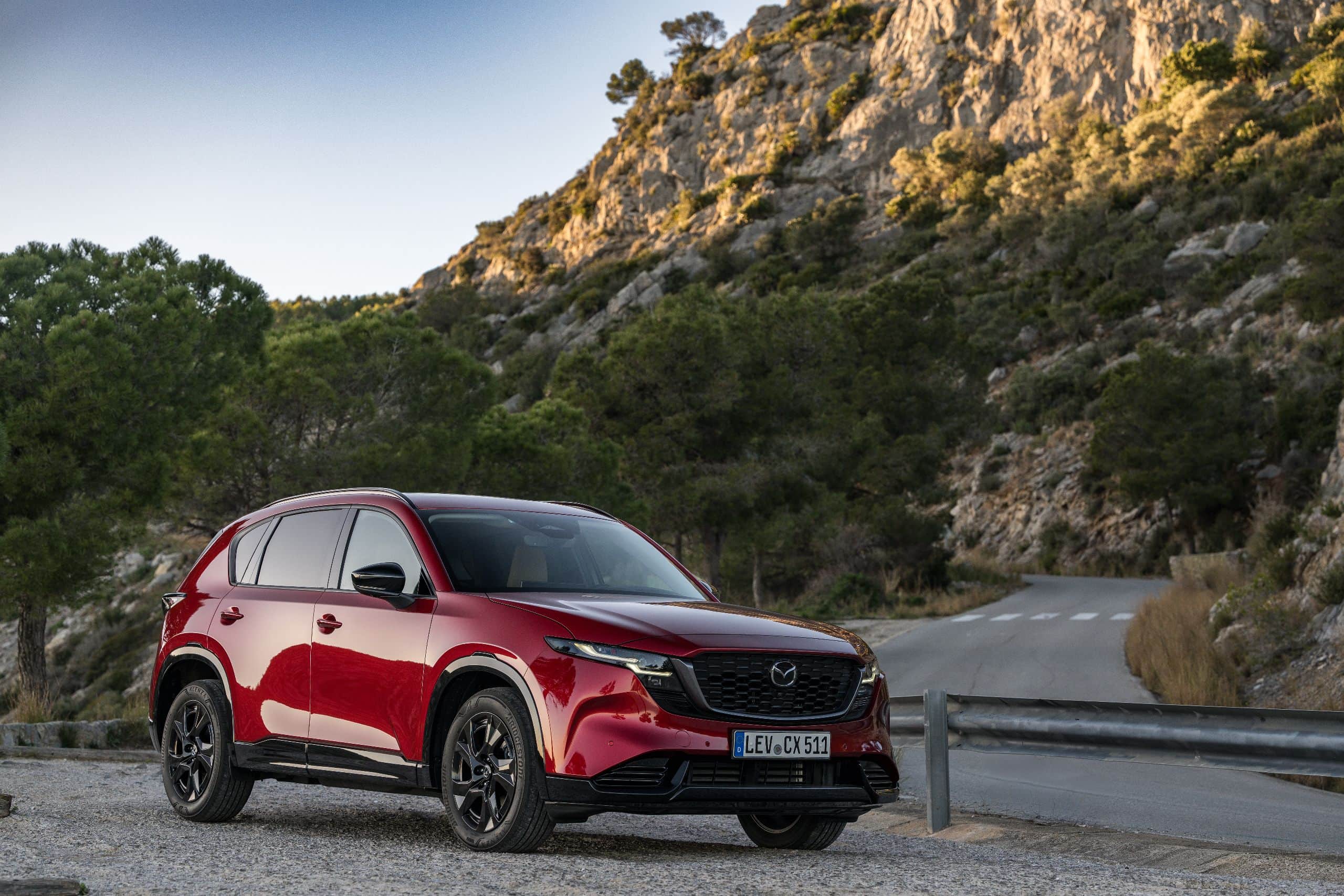 Der Mazda CX-5 2026 Homura in Soul Red Crystal fährt auf kurviger Bergstraße