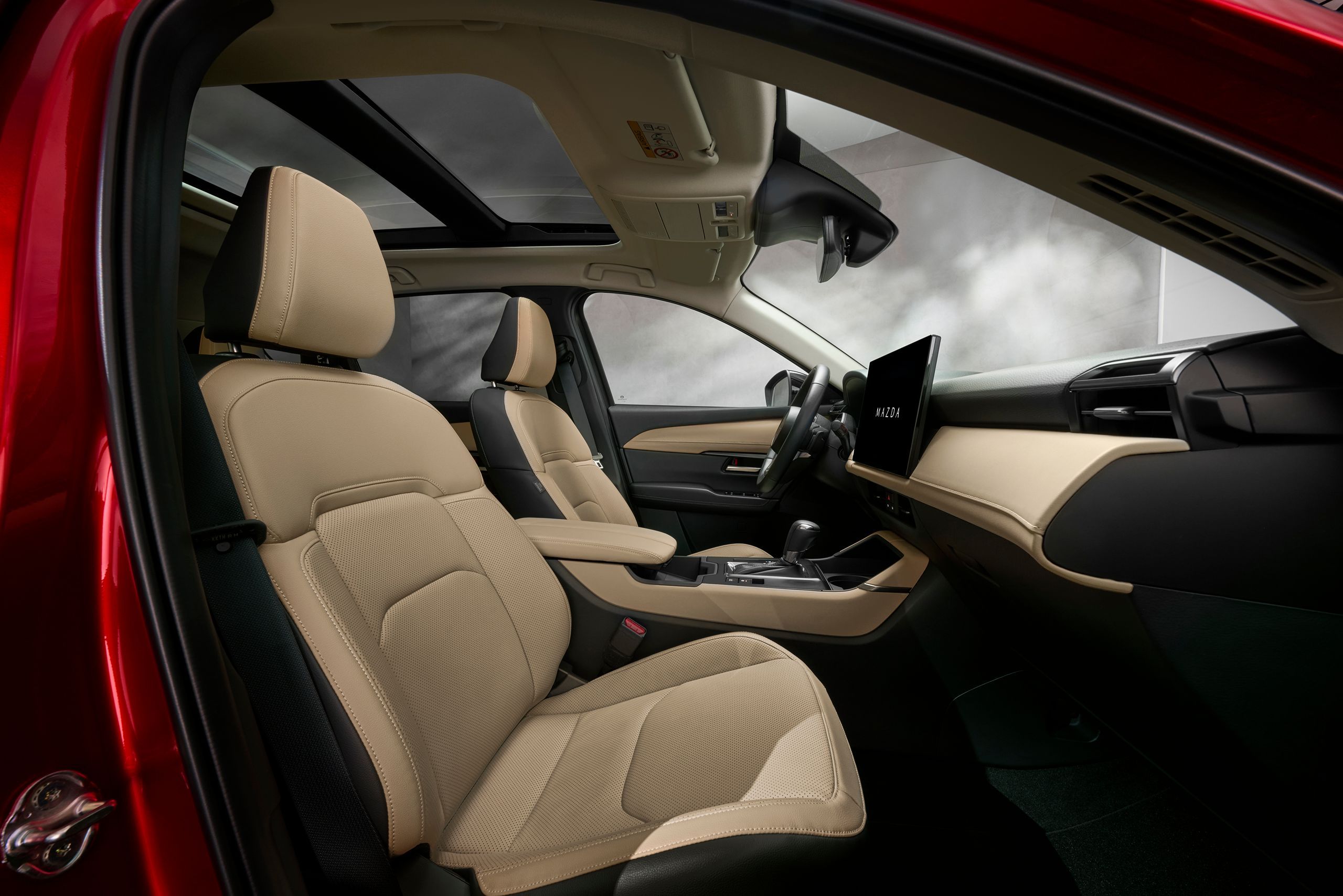 Mazda CX-5 2026 Innenraum mit hellen Ledersitzen, Mittelkonsole und Panorama-Glasschiebedach