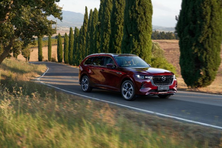 Mazda CX-80 2026 in Artisan Red auf mediterraner, zypressengesäumter Straße